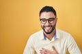 Hispanic young man wearing business clothes and glasses smiling and laughing hard out loud because funny crazy joke with hands on Royalty Free Stock Photo