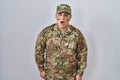 Hispanic young man wearing camouflage army uniform afraid and shocked with surprise expression, fear and excited face Royalty Free Stock Photo