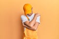 Hispanic young man wearing handyman uniform hugging oneself happy and positive, smiling confident Royalty Free Stock Photo