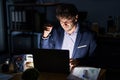 Hispanic young man working at the office at night angry and mad raising fist frustrated and furious while shouting with anger Royalty Free Stock Photo