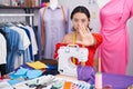 Hispanic young woman dressmaker designer using sewing machine doing stop sing with palm of the hand Royalty Free Stock Photo