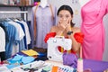 Hispanic young woman dressmaker designer using sewing machine shocked covering mouth with hands for mistake Royalty Free Stock Photo