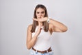 Hispanic young woman standing over white background doing time out gesture with hands, frustrated and serious face Royalty Free Stock Photo