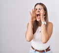 Hispanic young woman standing over white background shouting angry out loud with hands over mouth Royalty Free Stock Photo