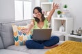 Hispanic young woman using laptop at home looking at the camera smiling with open arms for hug Royalty Free Stock Photo