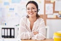 Hispanic young woman working at the office wearing headset and glasses happy face smiling with crossed arms looking at the camera Royalty Free Stock Photo