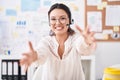 Hispanic young woman working at the office wearing headset and glasses looking at the camera smiling with open arms for hug Royalty Free Stock Photo