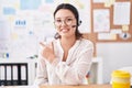 Hispanic young woman working at the office wearing headset and glasses smiling cheerful pointing with hand and finger up to the Royalty Free Stock Photo