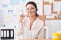 Hispanic young woman working at the office wearing headset and glasses smiling with an idea or question pointing finger up with Royalty Free Stock Photo