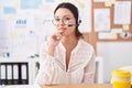 Hispanic young woman working at the office wearing headset and glasses smiling looking confident at the camera with crossed arms Royalty Free Stock Photo