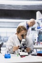 Histology technician examining stained tissue under microscope Royalty Free Stock Photo
