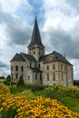 Historic abbey in Normandy with yellow flowers and expressive sky and cloudscape Royalty Free Stock Photo