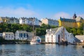 Historic boat house buildings, pier and traditional fishing boats along the waterfront of the harbour, Alesund, Norway. Royalty Free Stock Photo