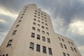 Historic Bucharest radio building with tall faÃ§ade and dramatic cloudy sky viewed from a low upward angle Royalty Free Stock Photo
