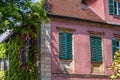 Historic building with lattice windows and green shutters