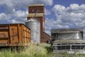 The historic Cadillac grain elevator in Saskatchewan, Canada with two old trucks in foreground