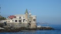 Historic castle in front of the sea with a Chilean flag flying on the tower