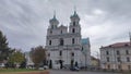 The historic church building with two towers, domes and crosses is covered with a metal roof. Nearby buildings are standing and tr Royalty Free Stock Photo