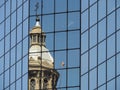 Church reflecting in glass wall of modern office building