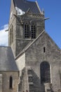 Historic church of Sainte mere l`eglise, with a paratrooper hanging on the bell tower.