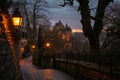 Historic Cobblestone Street With Lamp Post and Castle in Background, A lantern-lit walkway leading up to a charming old-world Royalty Free Stock Photo