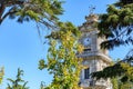 Historic Dolmabahce clock tower in istanbul with lush trees and clear blue sky Royalty Free Stock Photo