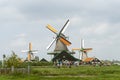 Historic Dutch Windmills at the village of Zaanse Schans in the Netherlands. Beautiful landscape with green grass a cloudy day