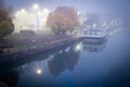 Historic Erie Canal in Fairport village with barge cruise boat tour, foggy morning mist and reflection of colorful fall foliage Royalty Free Stock Photo