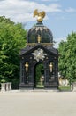 A historic gazebo decorated with sculptures, gold Griffin sculpture on the roof in the gardens of the Branicki Palace,
