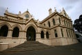 Beige gothic revival Parliamentary Library with classic colonnade porch entry on grand stairs, Wellington, New Zealand