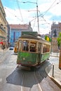 Historic green tram against old town streets, Lisbon, capital city of Portugal.