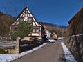 Historic half-timbered house with fence, stone wall and paved road in village Gundelfingen, part of MÃÂ¼nsingen, Germany.