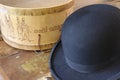 A historic hatbox from Berlin in the 19th century with a bowler on an old wooden table