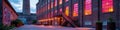 Historic industrial building with vibrant sunset reflections on windows at dusk Royalty Free Stock Photo