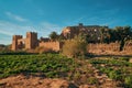 Historic ksar Ait Ben Haddou with green field by the sunset