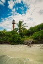 Historic lighthouse on shell beach with driftwood and palms in Sanibel island Florida Royalty Free Stock Photo