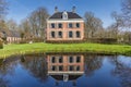 Historic mansion Ennemaborg with reflection in the pond in Midwolda