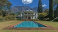 Historic mansion with pool, lush gardens, and mountains Royalty Free Stock Photo