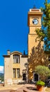 Historic medieval clock tower and tenement houses at Place du 24 Aout square in old town of perfumery city of Grasse in France