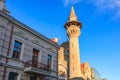 Historic mosque minaret against blue sky in urban setting Royalty Free Stock Photo