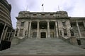 Old Edwardian parliament in grey stone with classic colonnade entry on grand stairs, Wellington, New Zealand