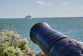 Historic old Large Canon aims out to sea at passenger ferry. Royalty Free Stock Photo