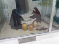 A historic picture, inwhich two womens are grinding corn.