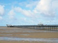 Historic pier at southport merseyside with the beach at low tide and summer sky reflected in water on the beach Royalty Free Stock Photo