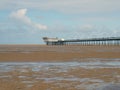 Historic pier at southport merseyside with the beach at low tide and summer sky reflected in water on the beach Royalty Free Stock Photo