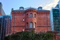 Historic red brick building surrounded by modern office buildings Royalty Free Stock Photo