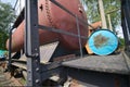 Historic red tank car with a tank for liquids behind an iron platform with a blue oil barrel Royalty Free Stock Photo