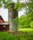 Historic restored round silo  and red barn in spring Royalty Free Stock Photo
