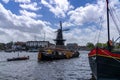 Historic river houseboat and dingy arriving in the marina on the canals of Haarlem
