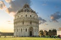 The historic, round Baptistery next to the tower and Duomo on the Field of Miracles, in the Tuscan city of Pisa Italy at sunset